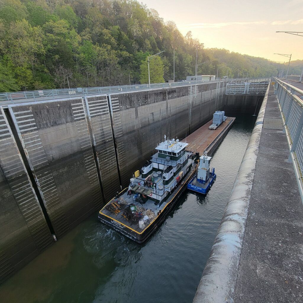 An aerial view of a large ship in the middle of a large body of water at sunset.