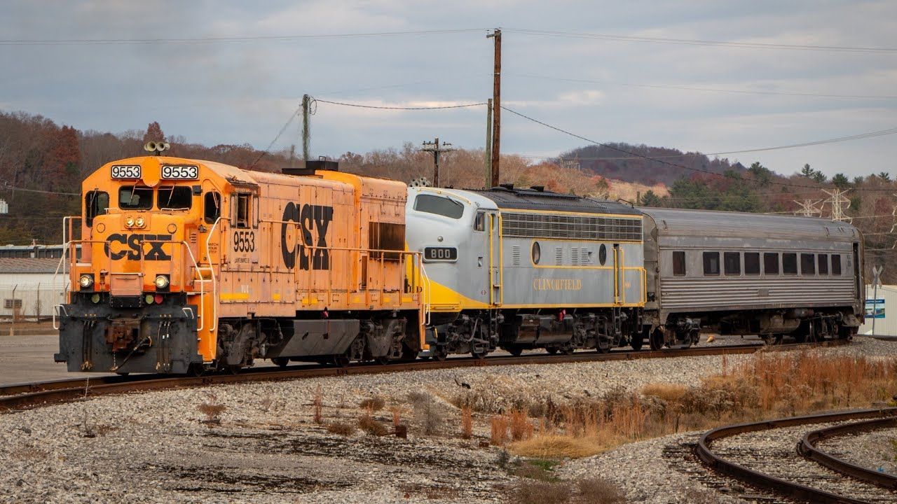 A train is traveling down train tracks next to a river.