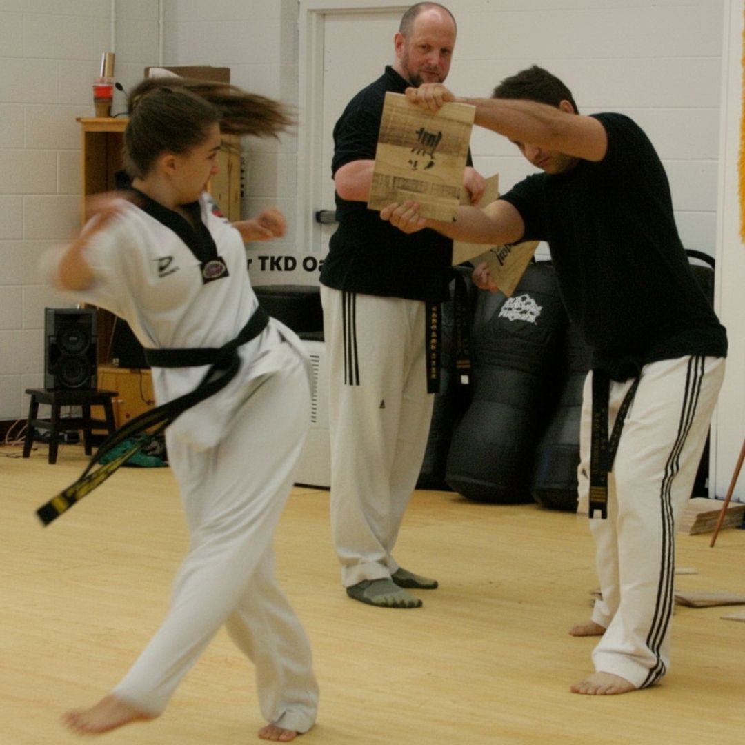 Two people practicing Brazilian Jiu-Jitsu on a mat. One is on top, applying a hold.
