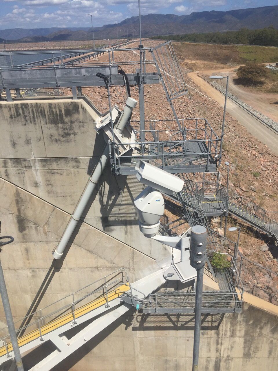 An aerial view of a dam with a lot of cameras on it.