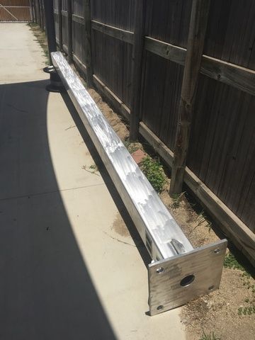 Metal Pole is Placed on the Sidewalk Next to a Wooden Fence — Sape Industries in Garbutt, QLD