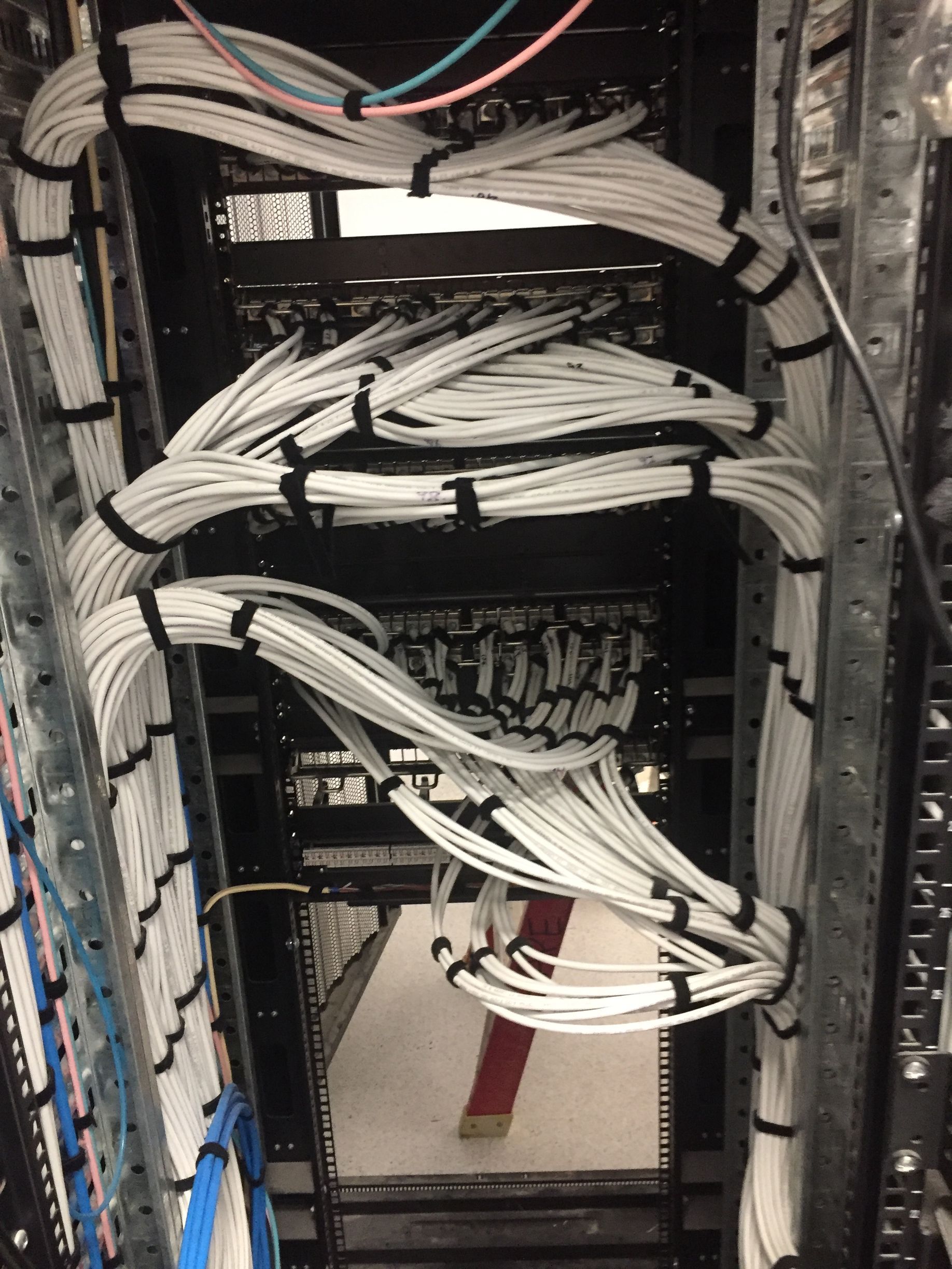 A bunch of wires are connected to a server rack