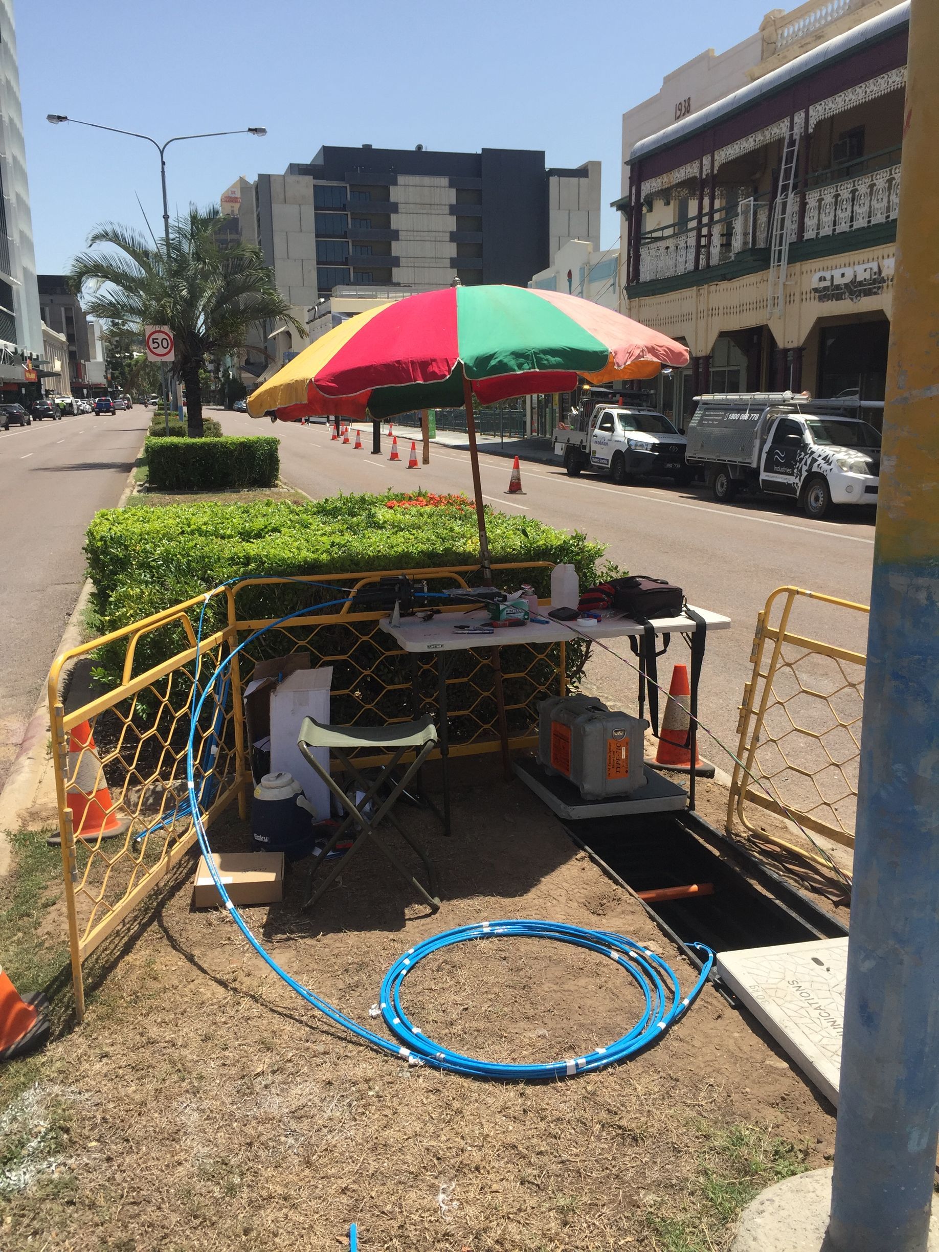 A colorful umbrella is sitting on the side of the road.