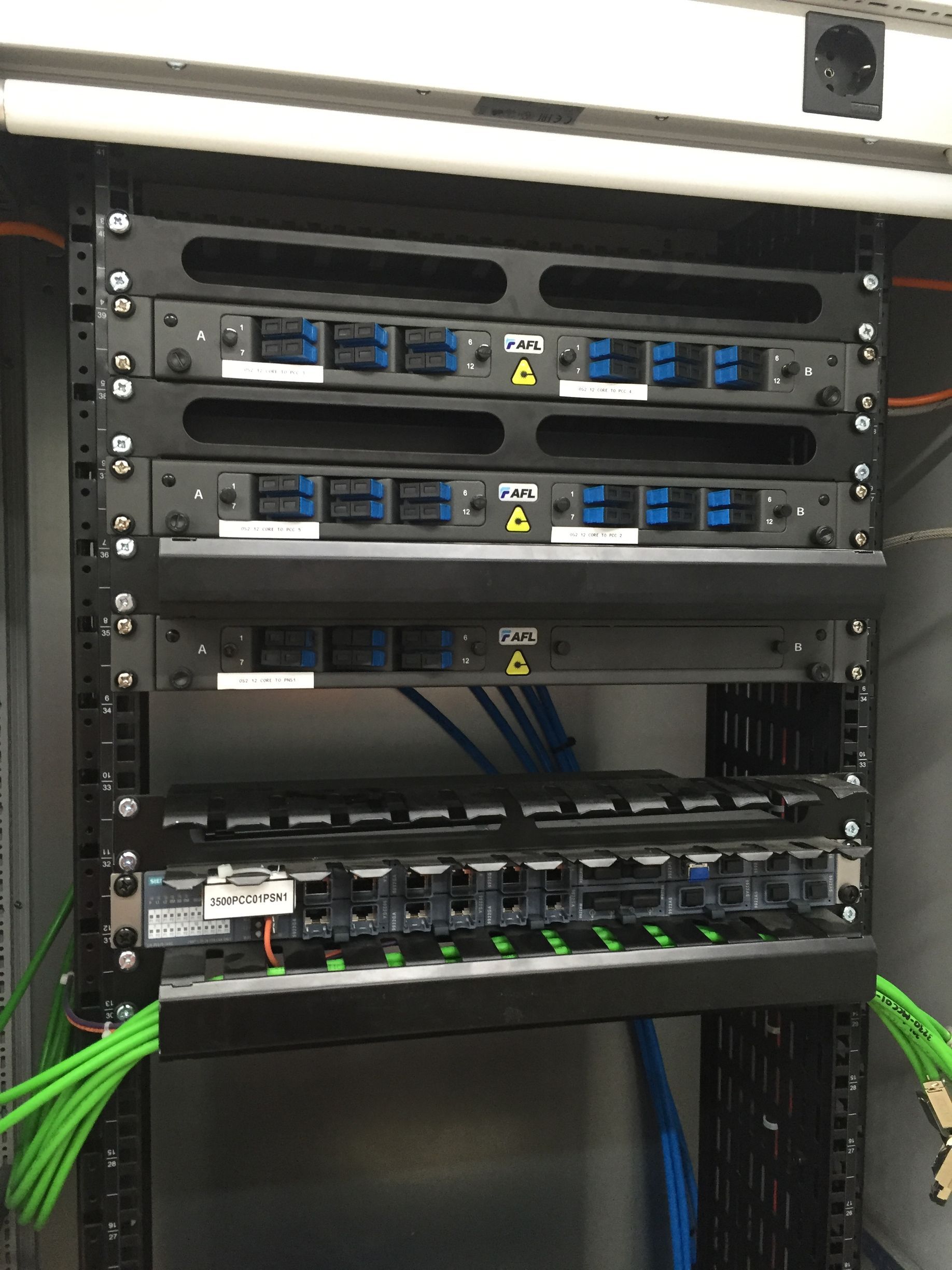 A server rack with a lot of wires coming out of it