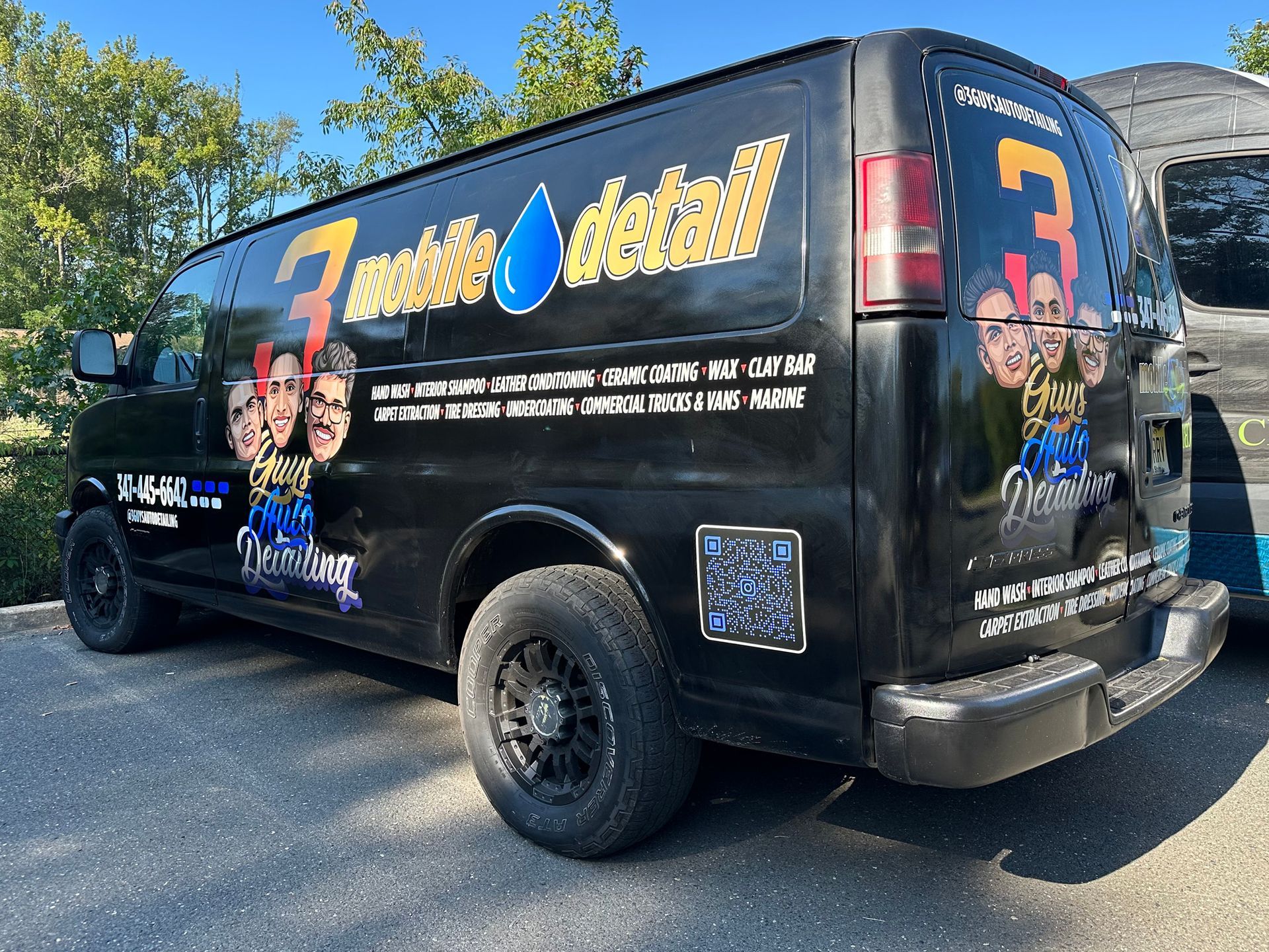 A black van with the number 3 on the back is parked in a parking lot.