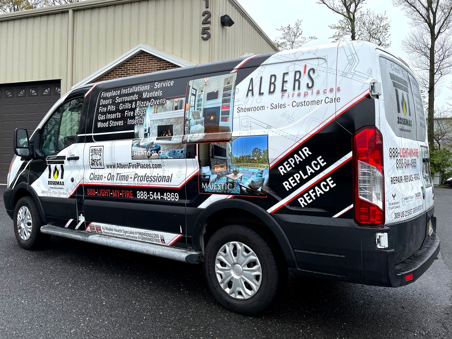 A black and white van is parked in front of a building.