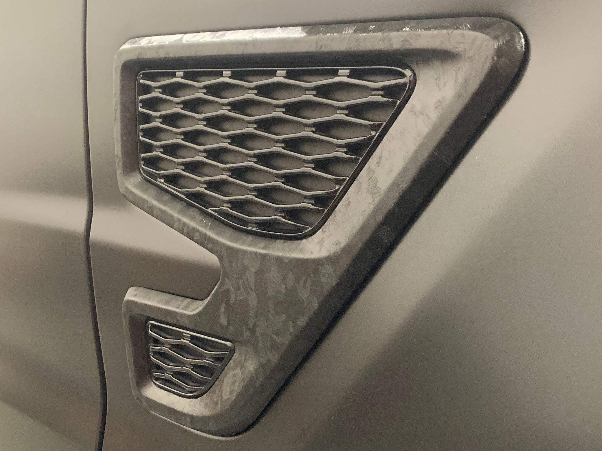 A close up of the side of a car with a grill on it