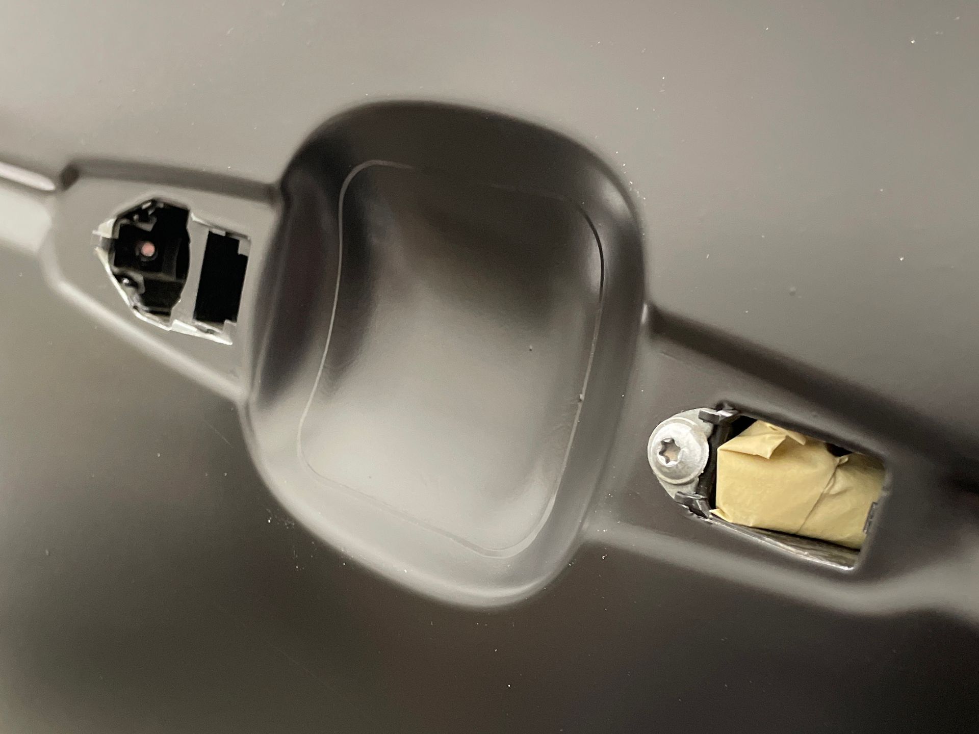 A close up of a car door handle with a screw in it