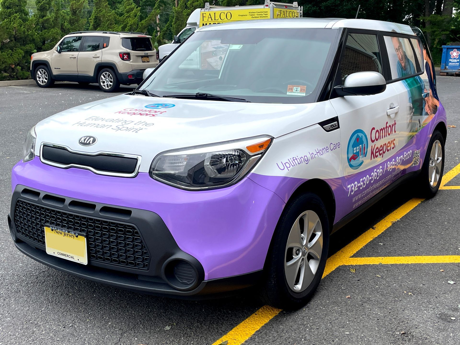 A purple and white car is parked in a parking lot.