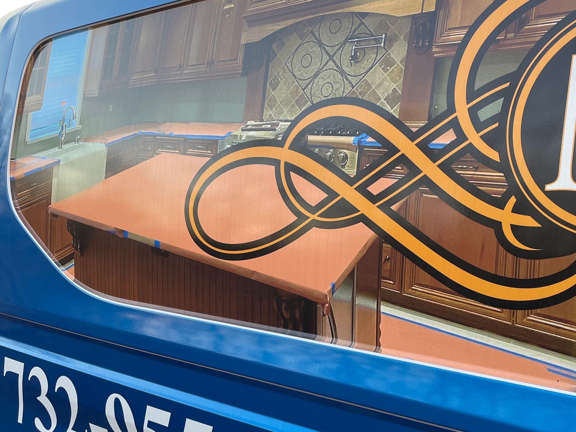 A blue van with a picture of a kitchen in the window