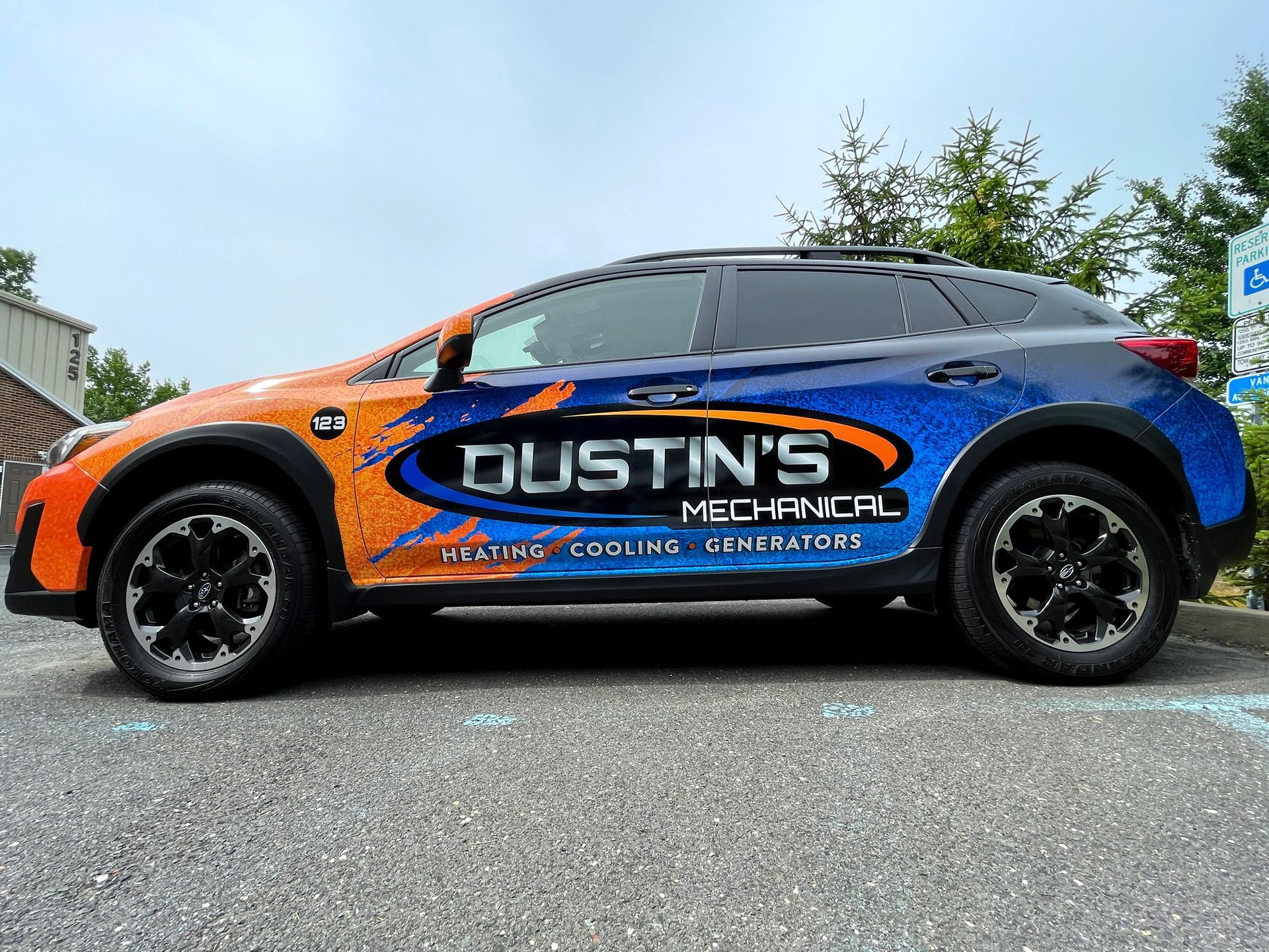 A blue and orange suv with dustin 's mechanical written on the side