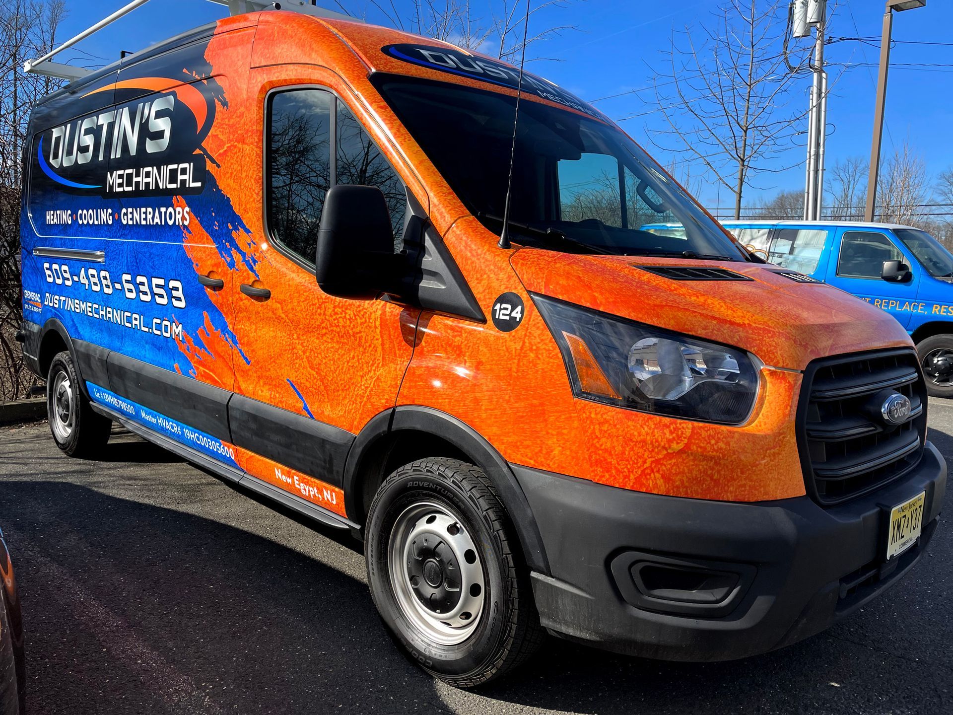 An orange van is parked in a parking lot.