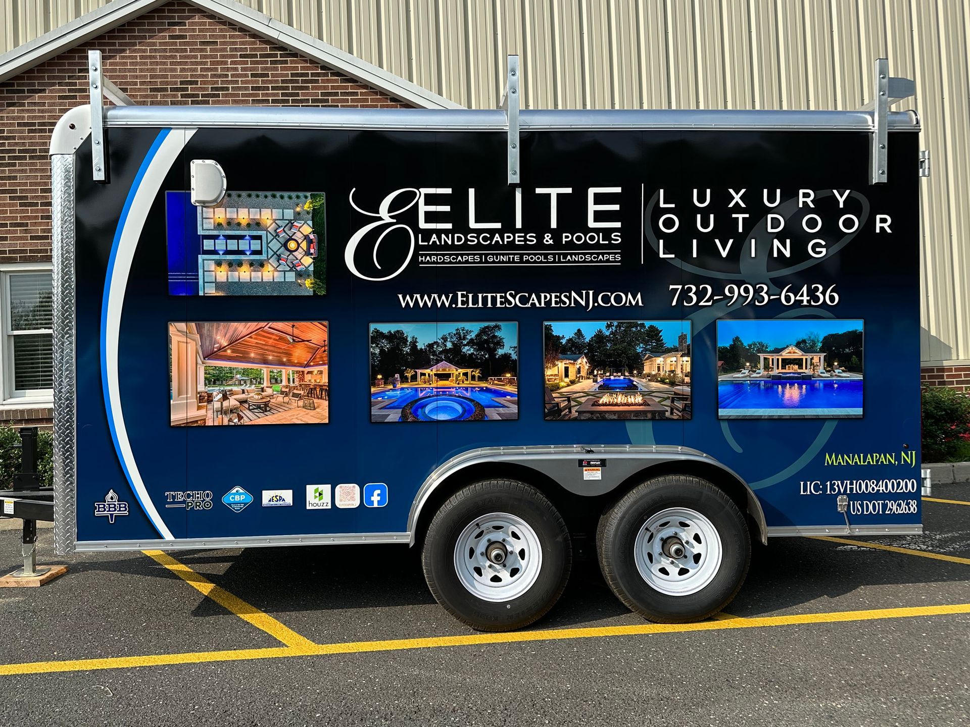 A trailer for elite luxury outdoor living is parked in a parking lot