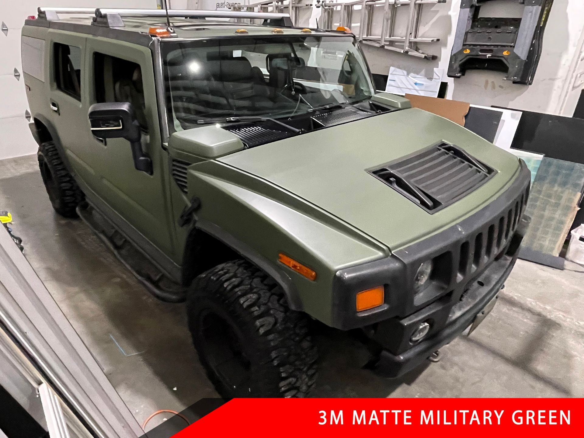 A hummer h2 is wrapped in 3m matte military green.