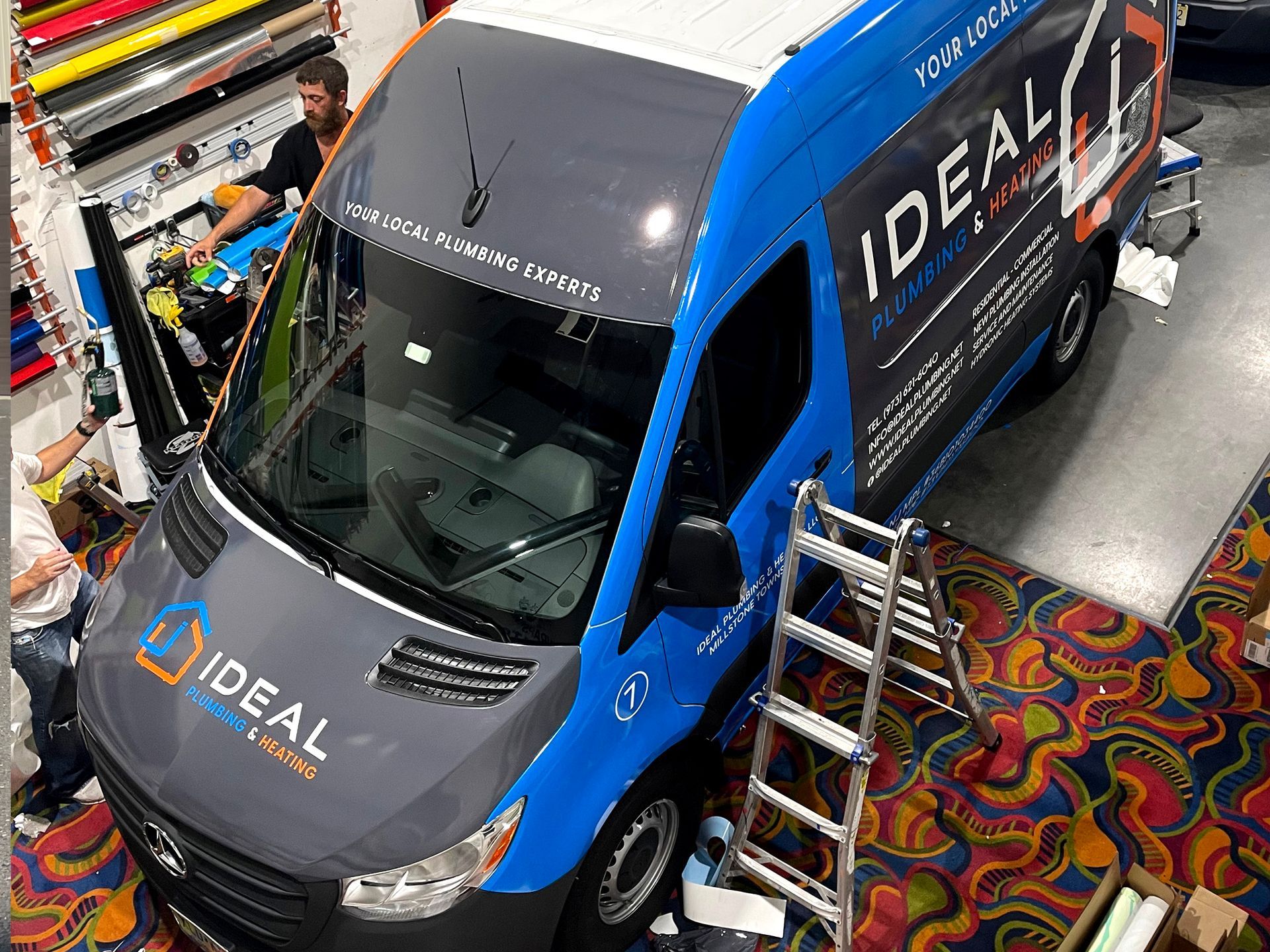 A blue and gray van with the word ideal on it