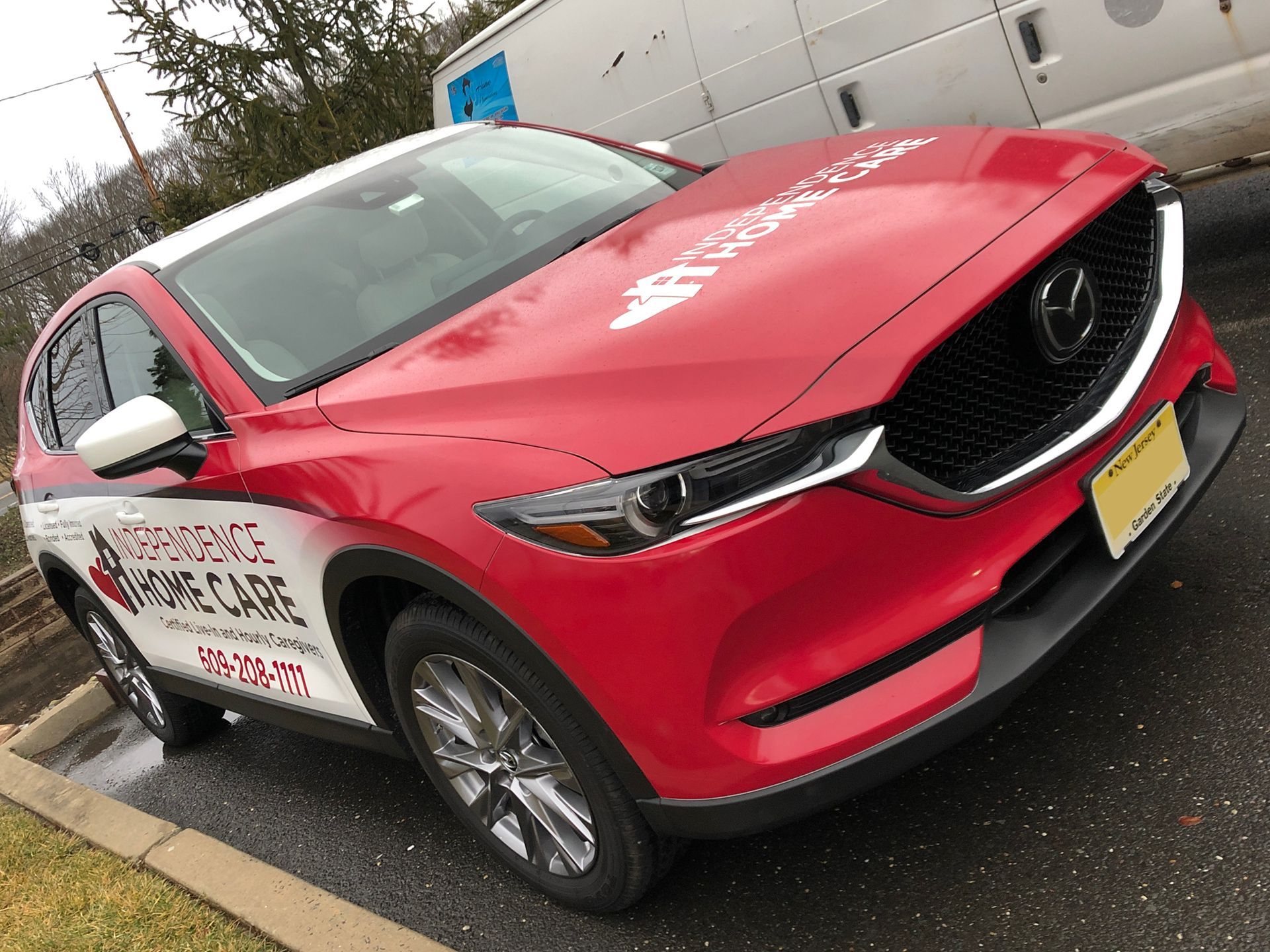 A red and white mazda cx 5 is parked on the side of the road