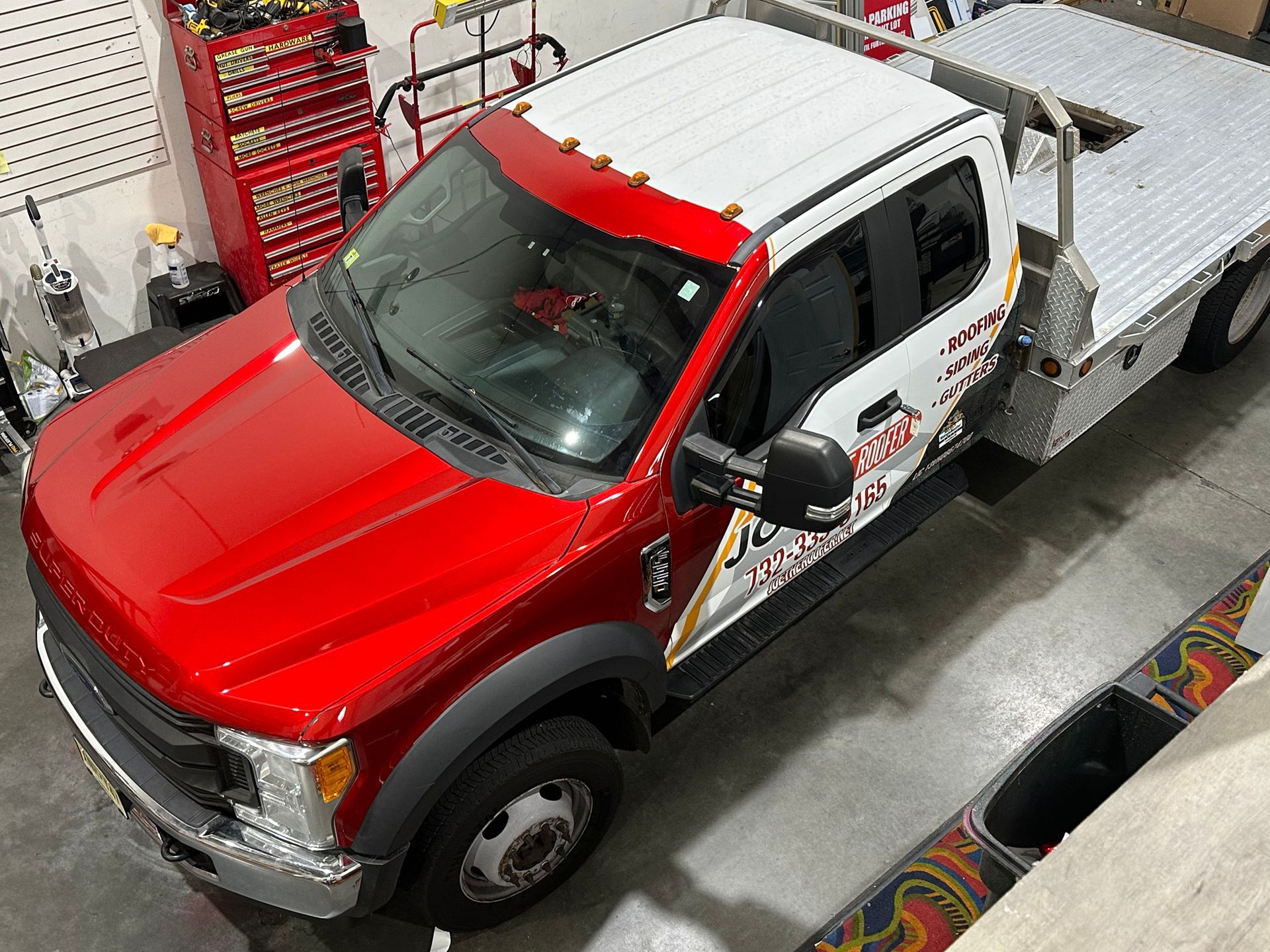 A red and white tow truck is parked in a garage.