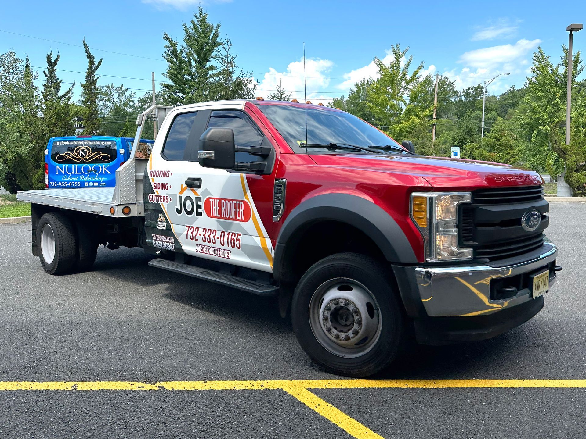 A red and white tow truck is parked in a parking lot.