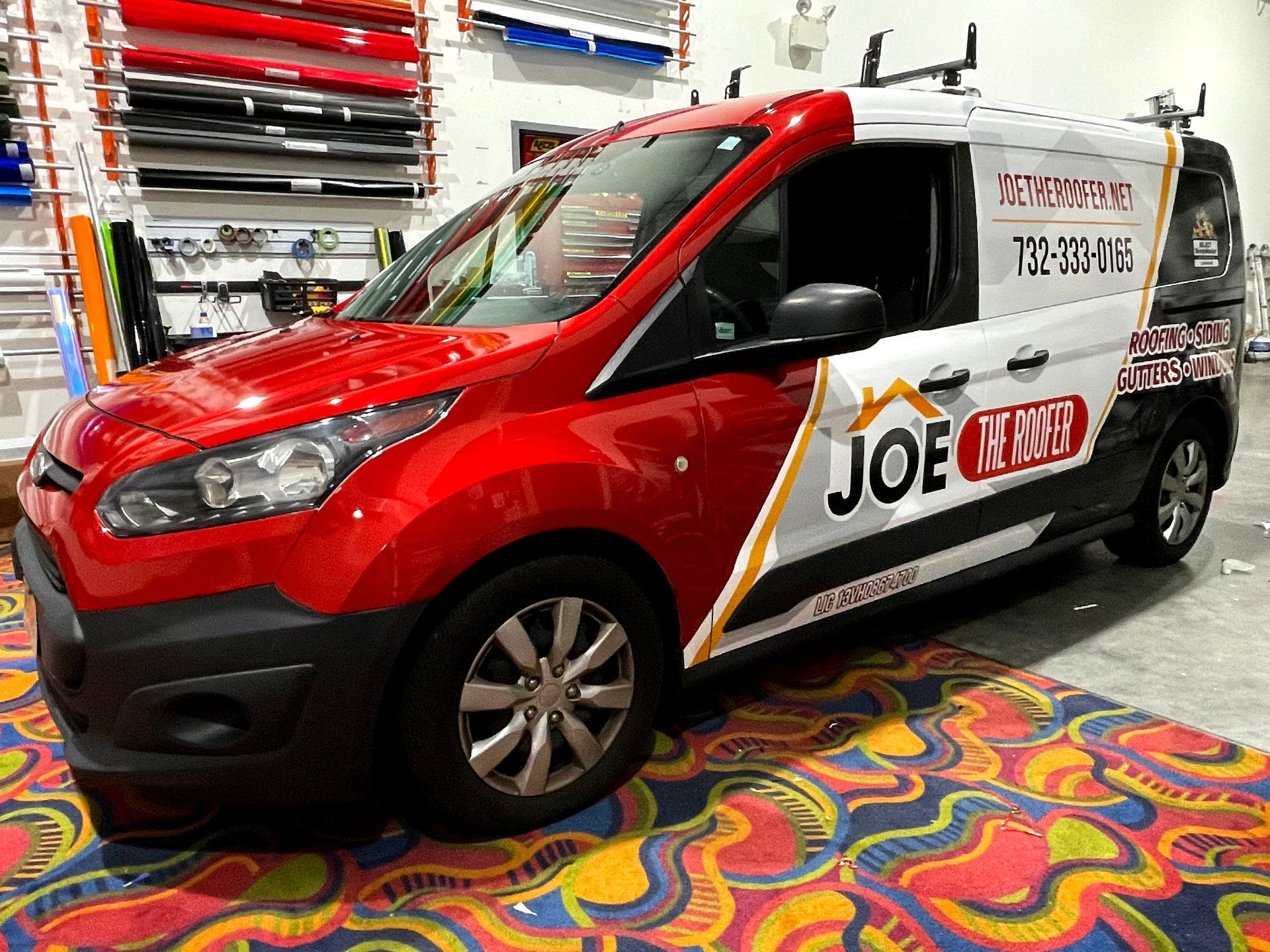 A red and white van is parked on a colorful carpet.