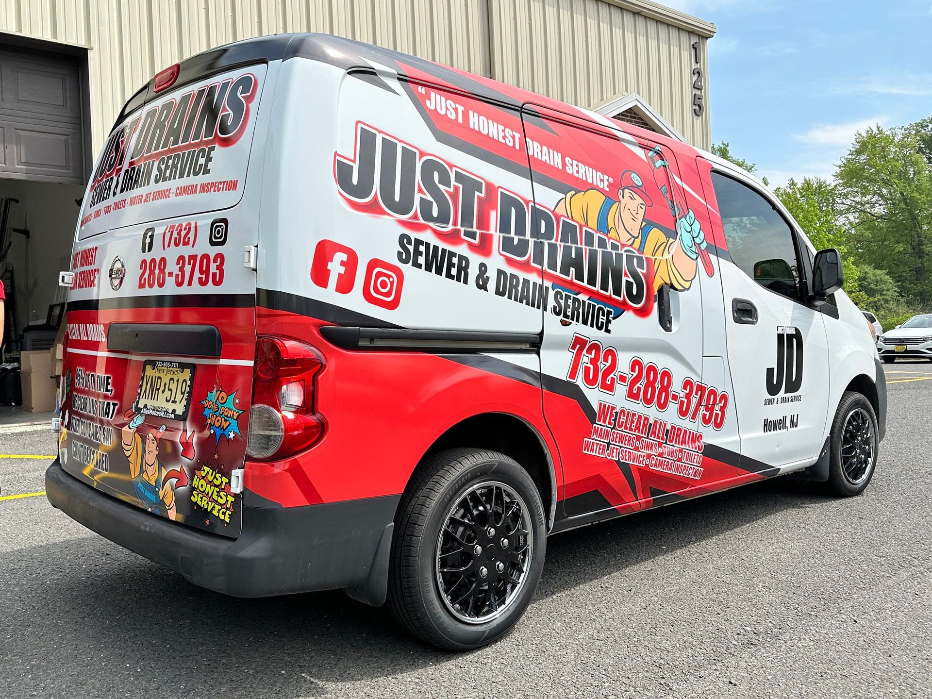 A red and white van is parked in front of a building.