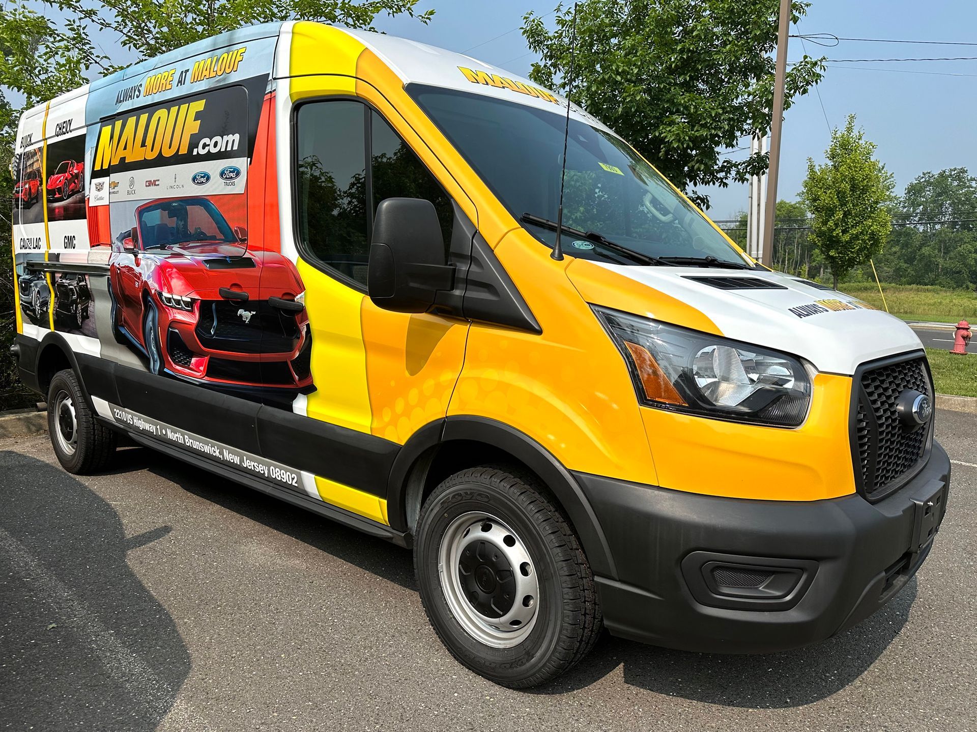 A yellow and white van is parked in a parking lot.
