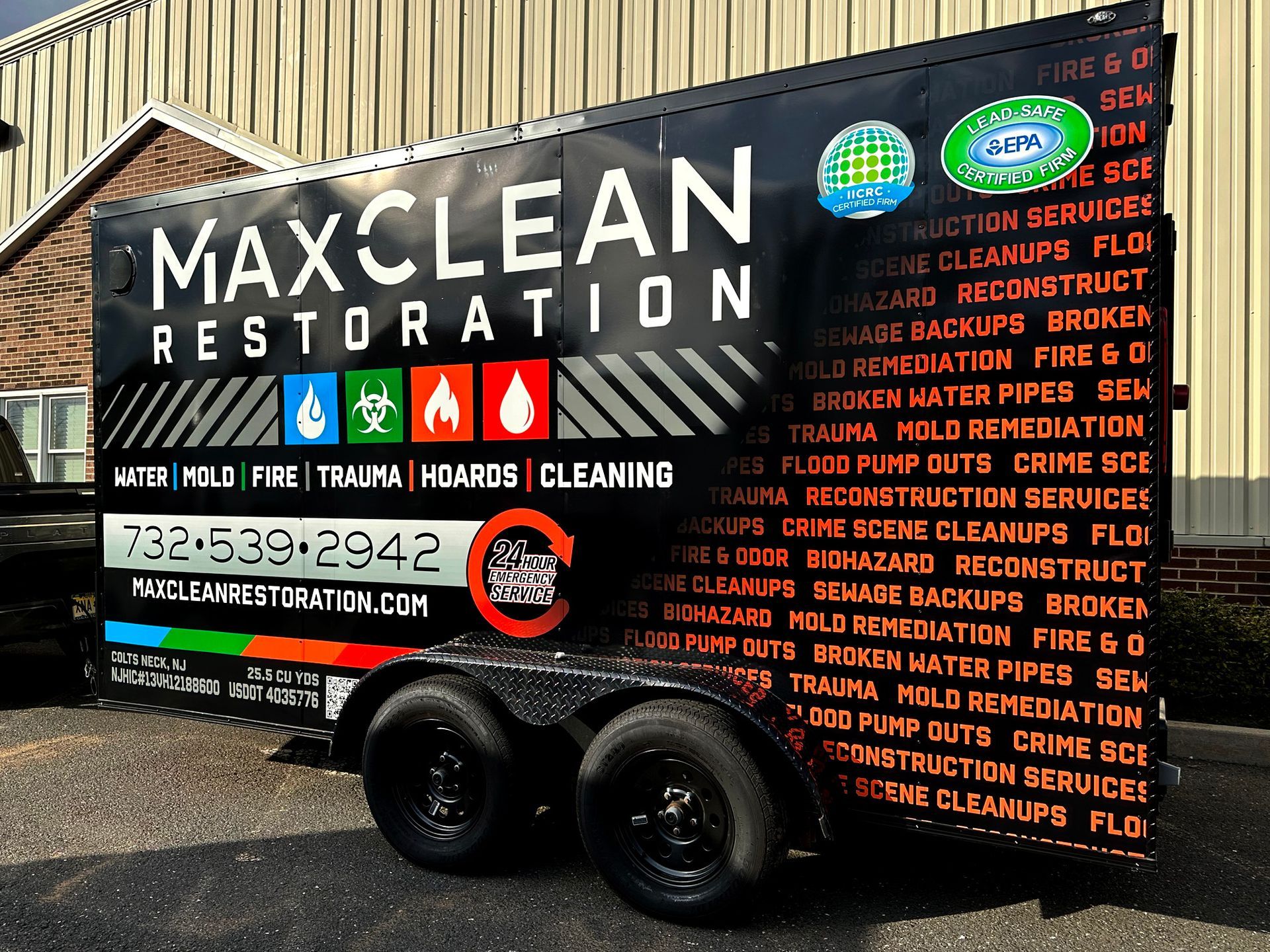 A trailer for maxclean restoration is parked in front of a building