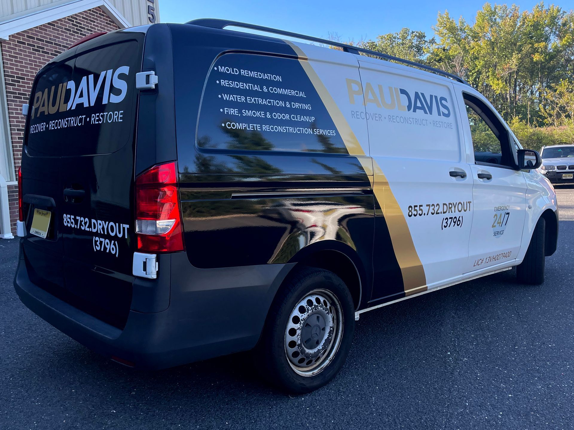 A black and white van is parked in a parking lot.