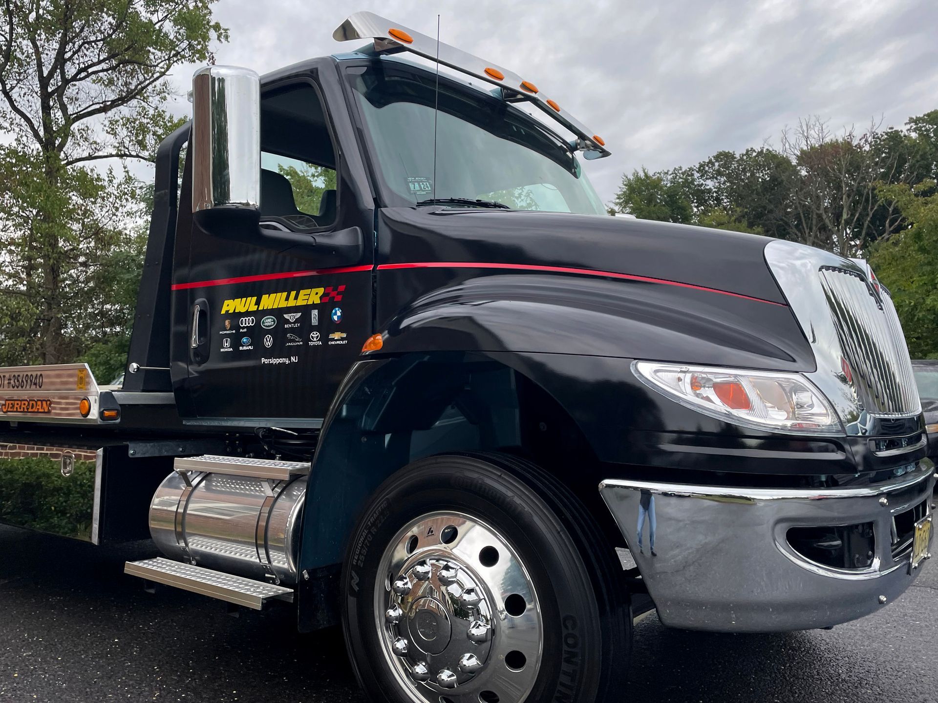 A black tow truck is parked on the side of the road.