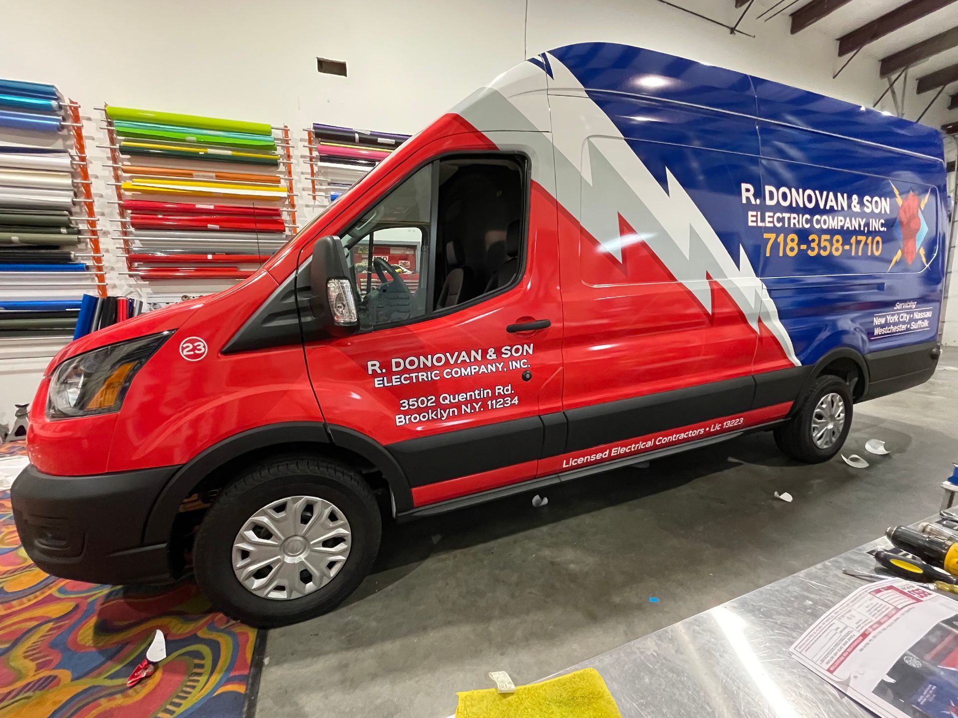 A red and blue van is sitting in a room.