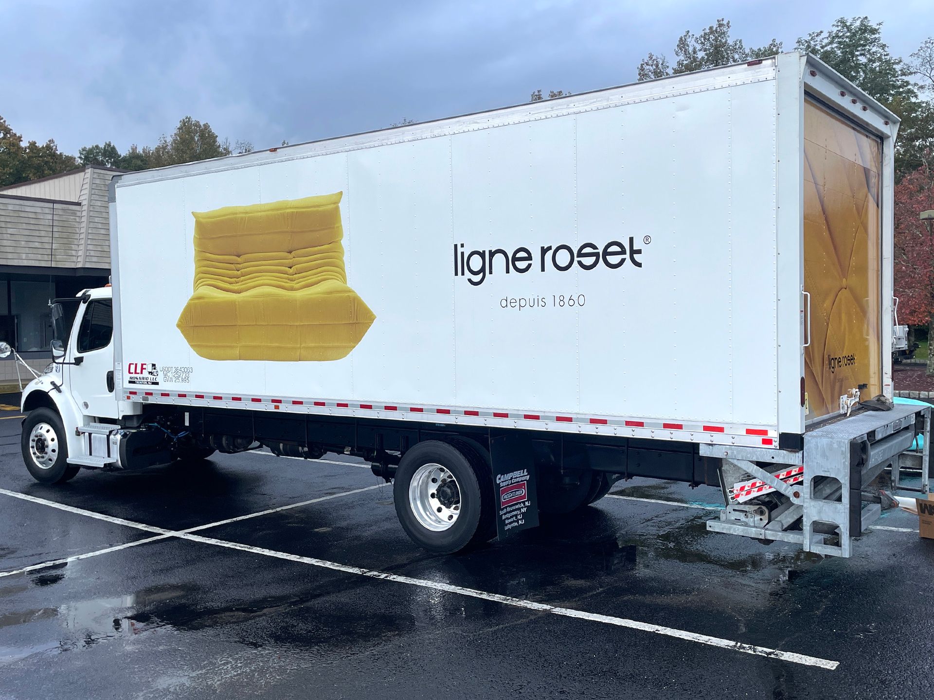 A white truck with the word ligneroset on the side is parked in a parking lot.