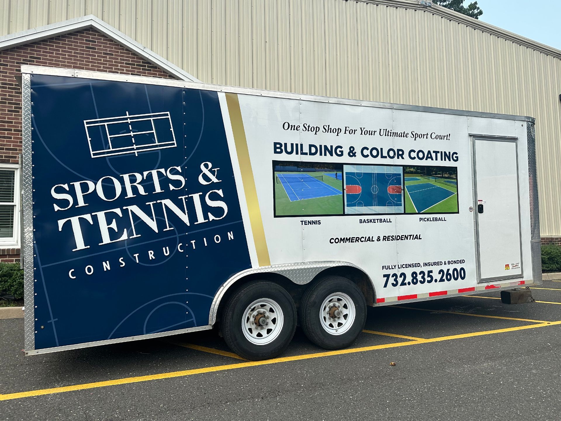 A sports and tennis trailer is parked in a parking lot