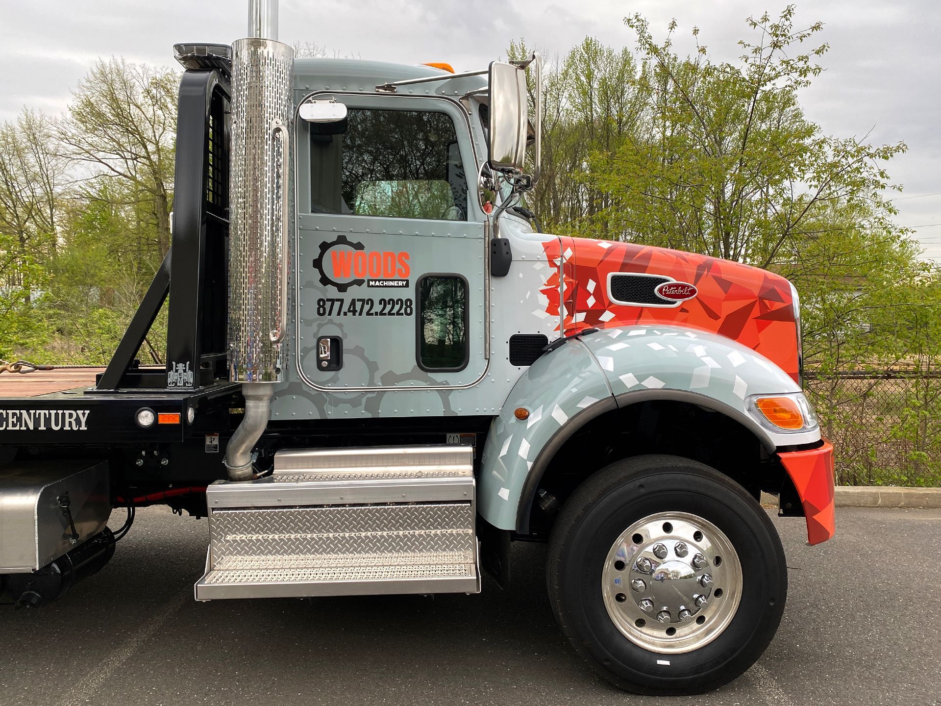 A century tow truck is parked on the side of the road