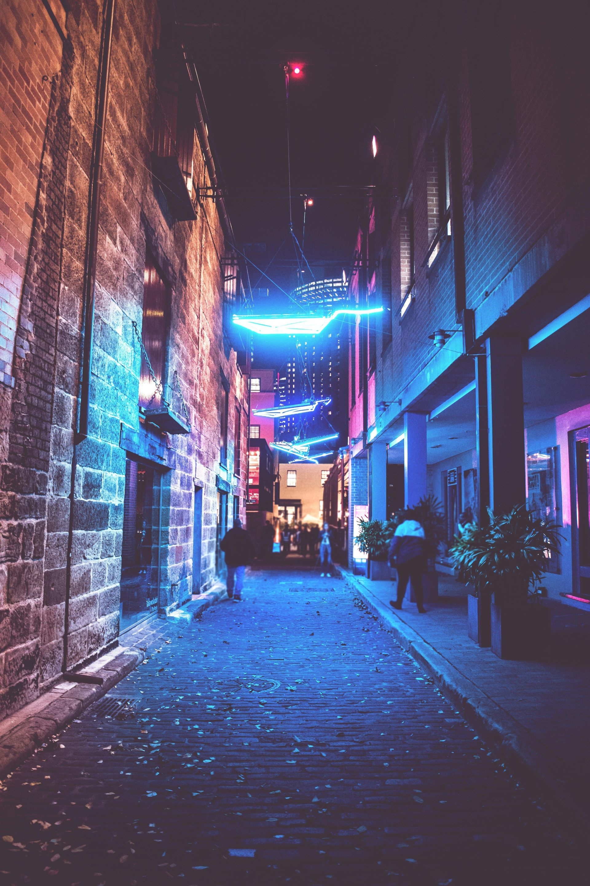alley in city at night with blue neon lights