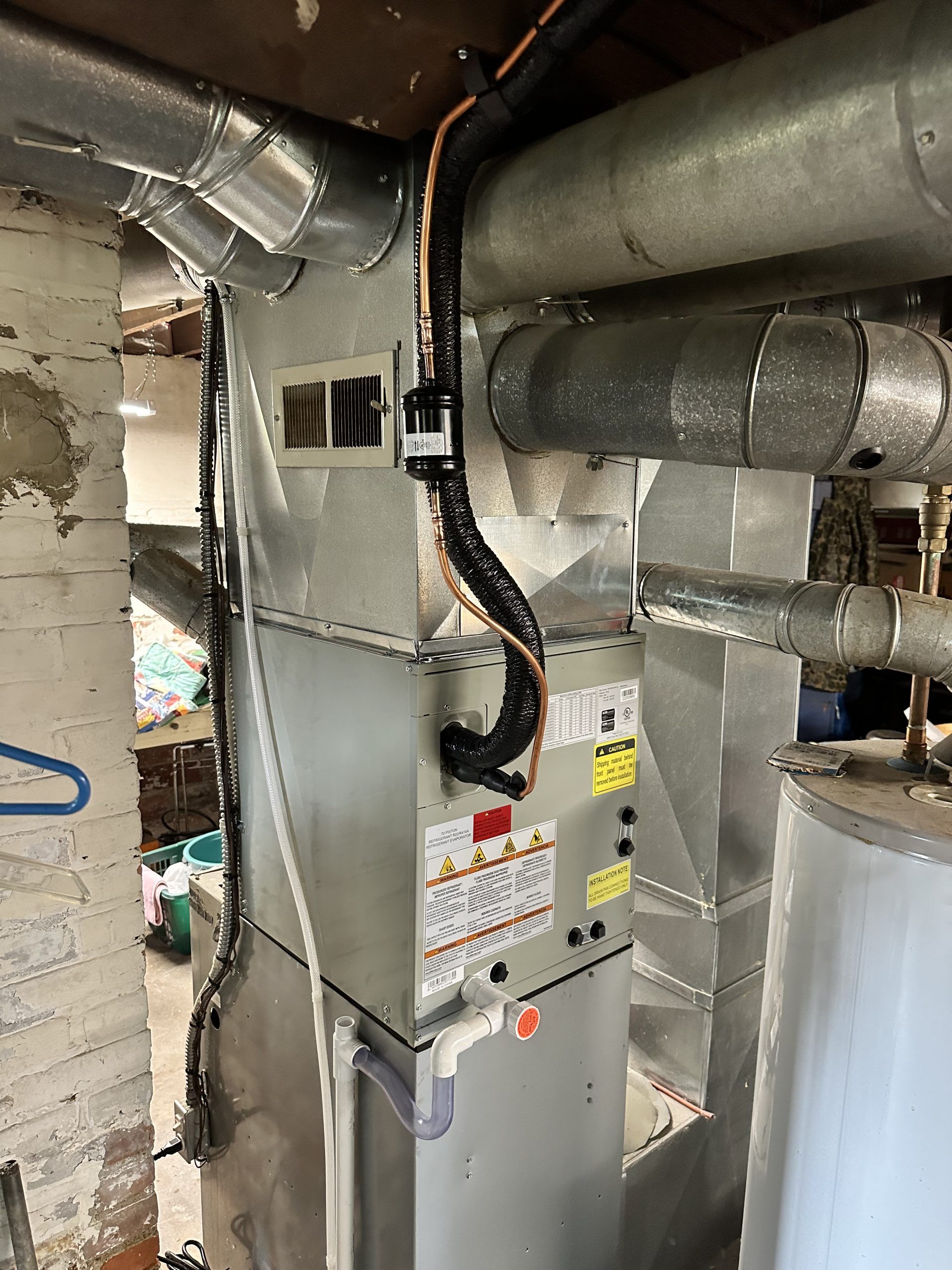 HVAC system with ductwork, water heater in a basement.