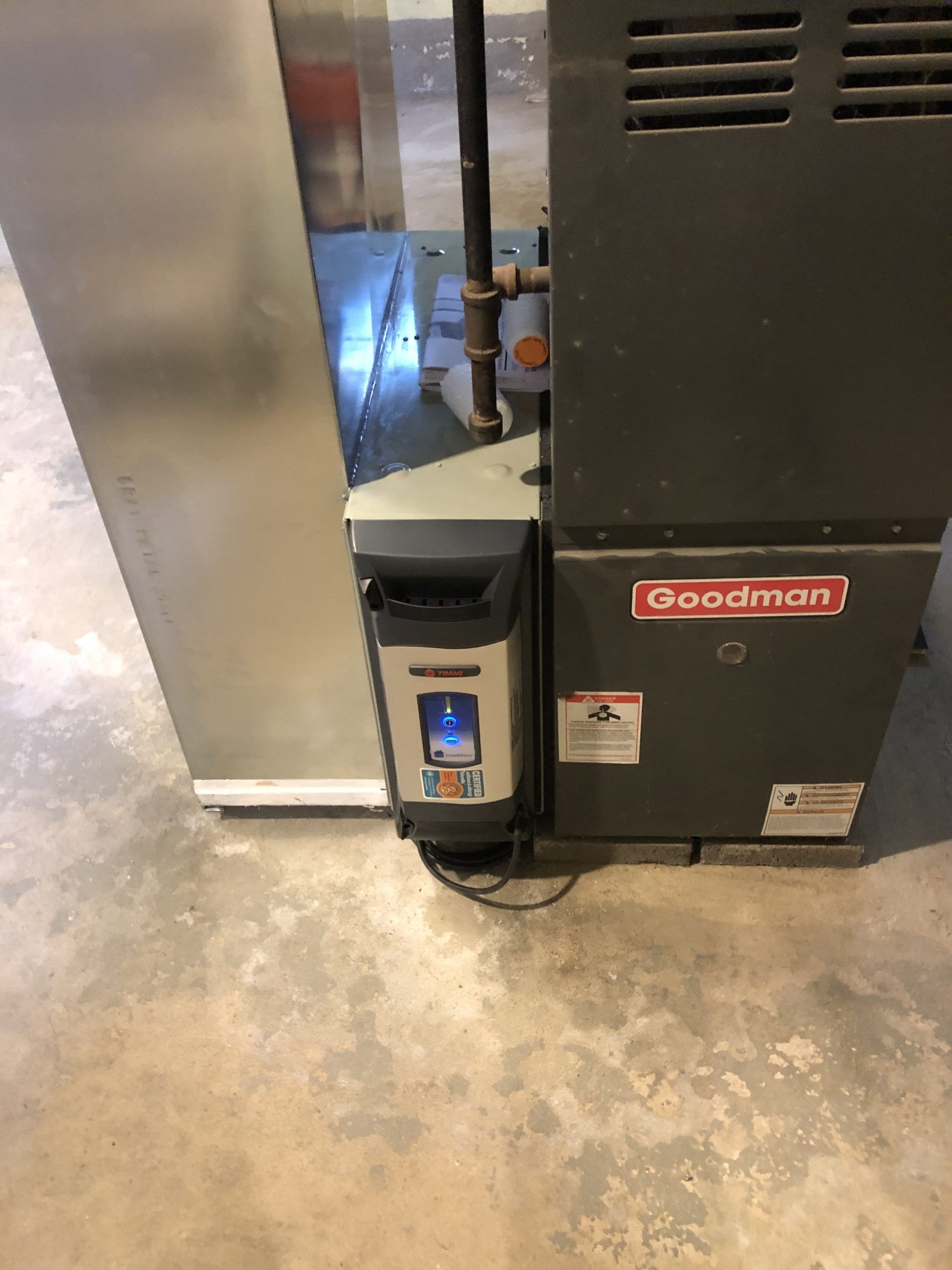 Goodman furnace with attached humidifier in a basement.