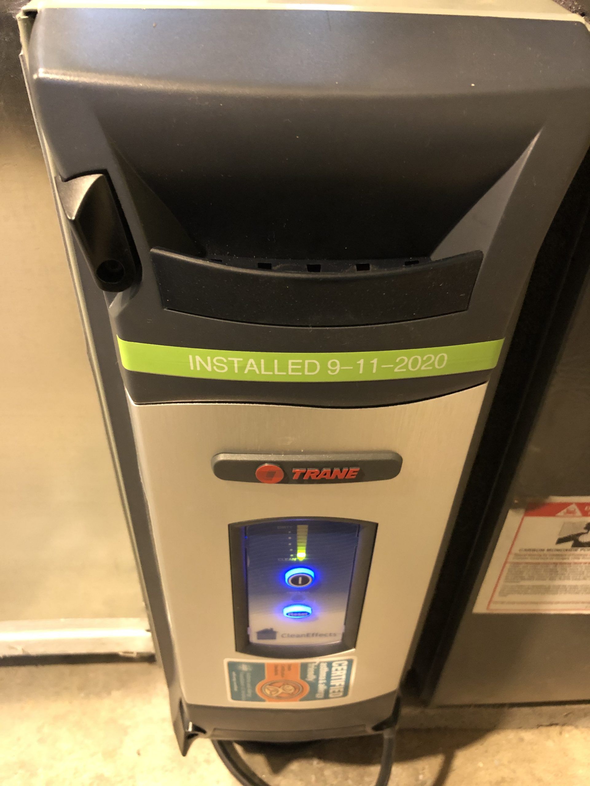 Gray and black Trane furnace with a lit blue display. 