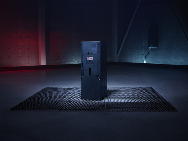Dark, industrial room; a black, rectangular machine on a metal grate. Red and blue lighting.
