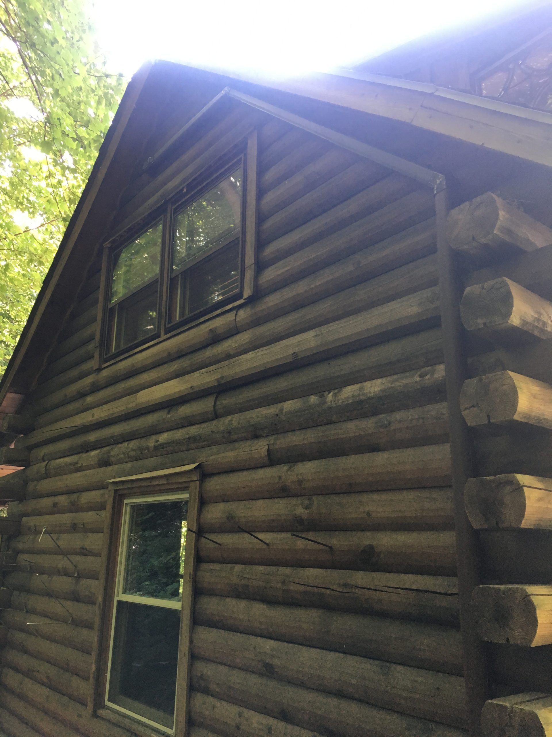 Log cabin with brown logs and windows.