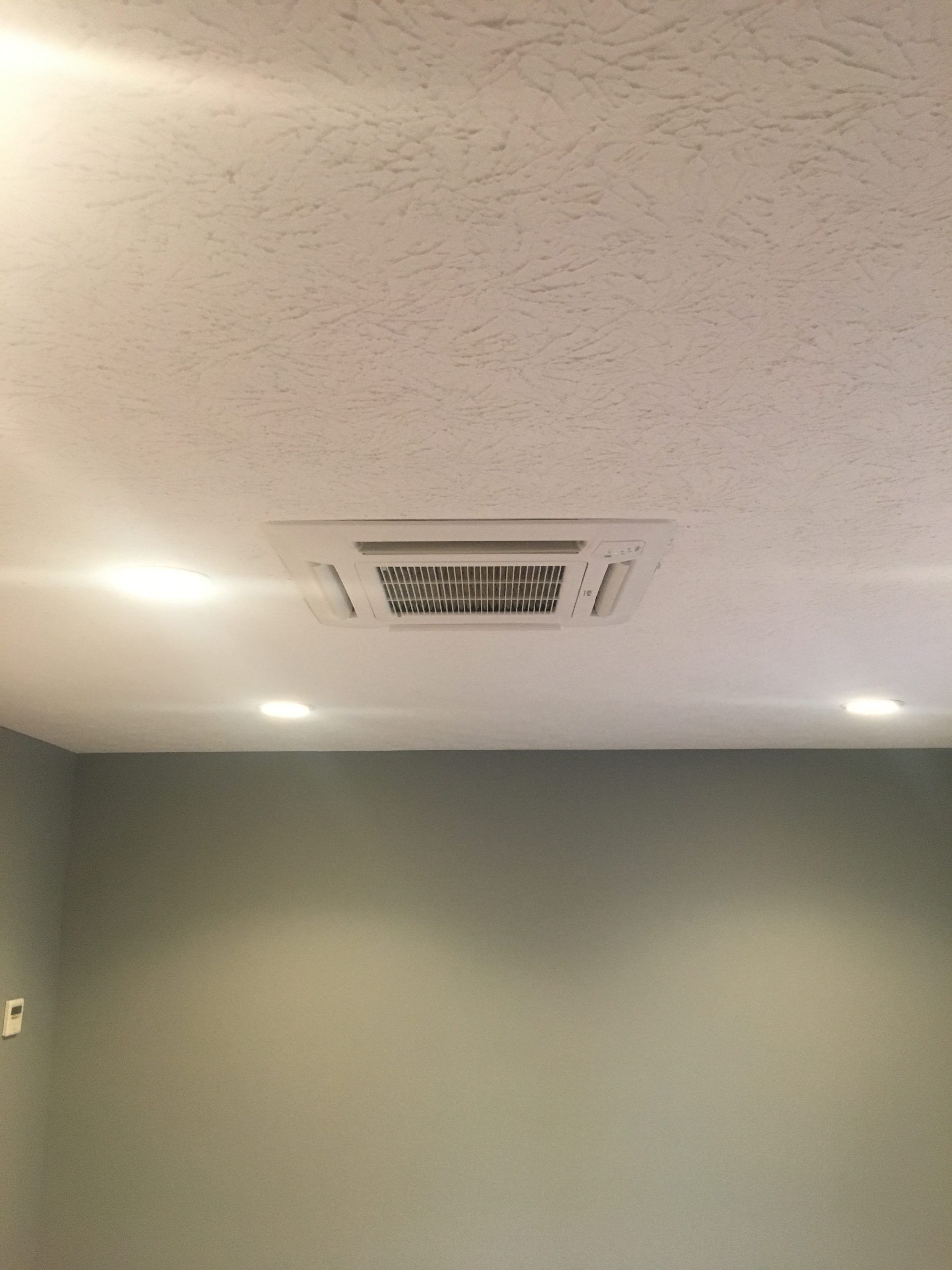 White ceiling with recessed HVAC unit and recessed lighting; gray wall.