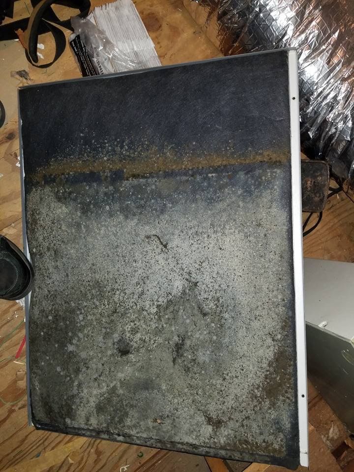 Dirty, rectangular air filter; bottom portion is caked with grime, top is cleaner.