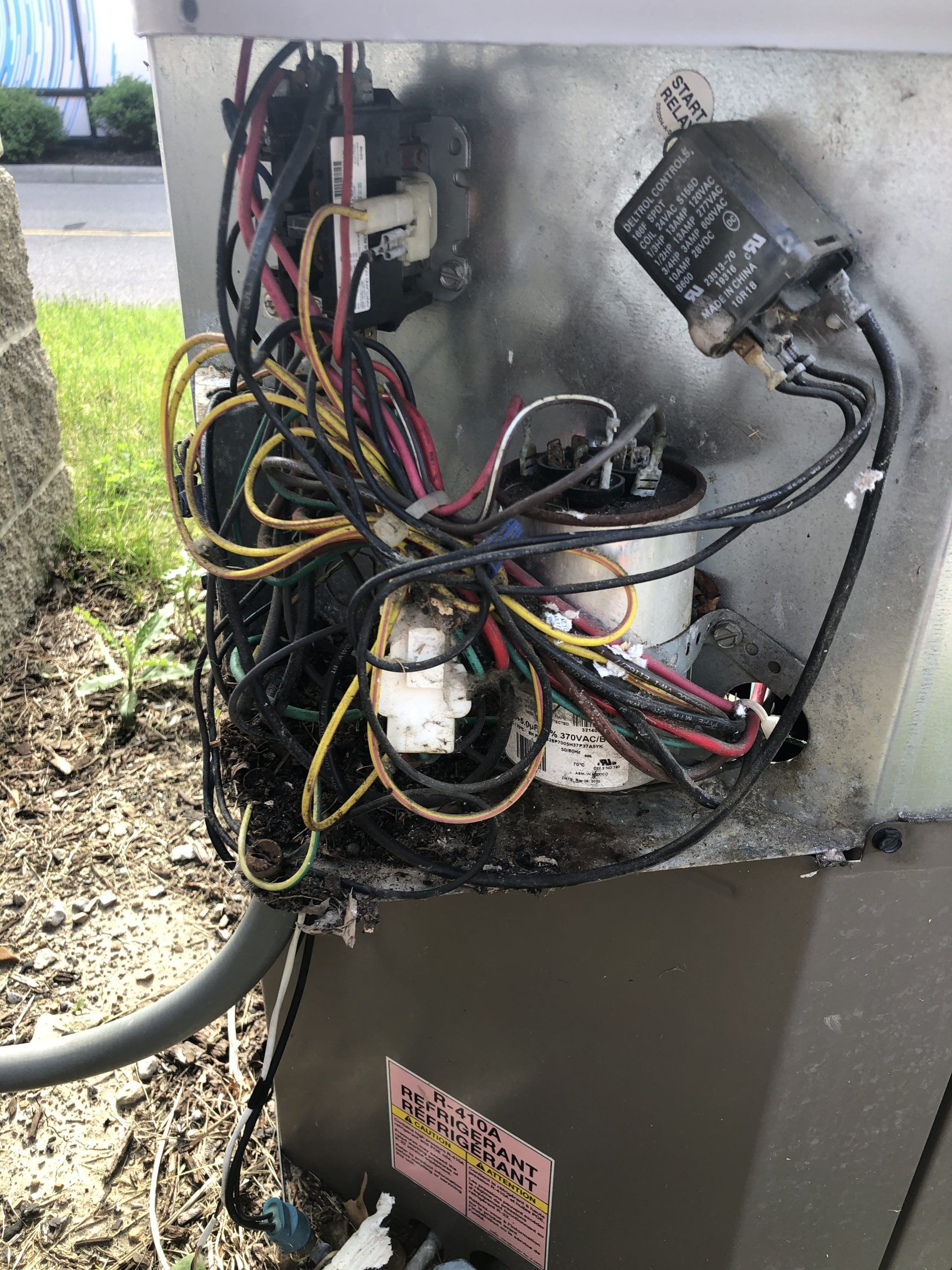 Damaged air conditioner unit with burnt wiring and components.