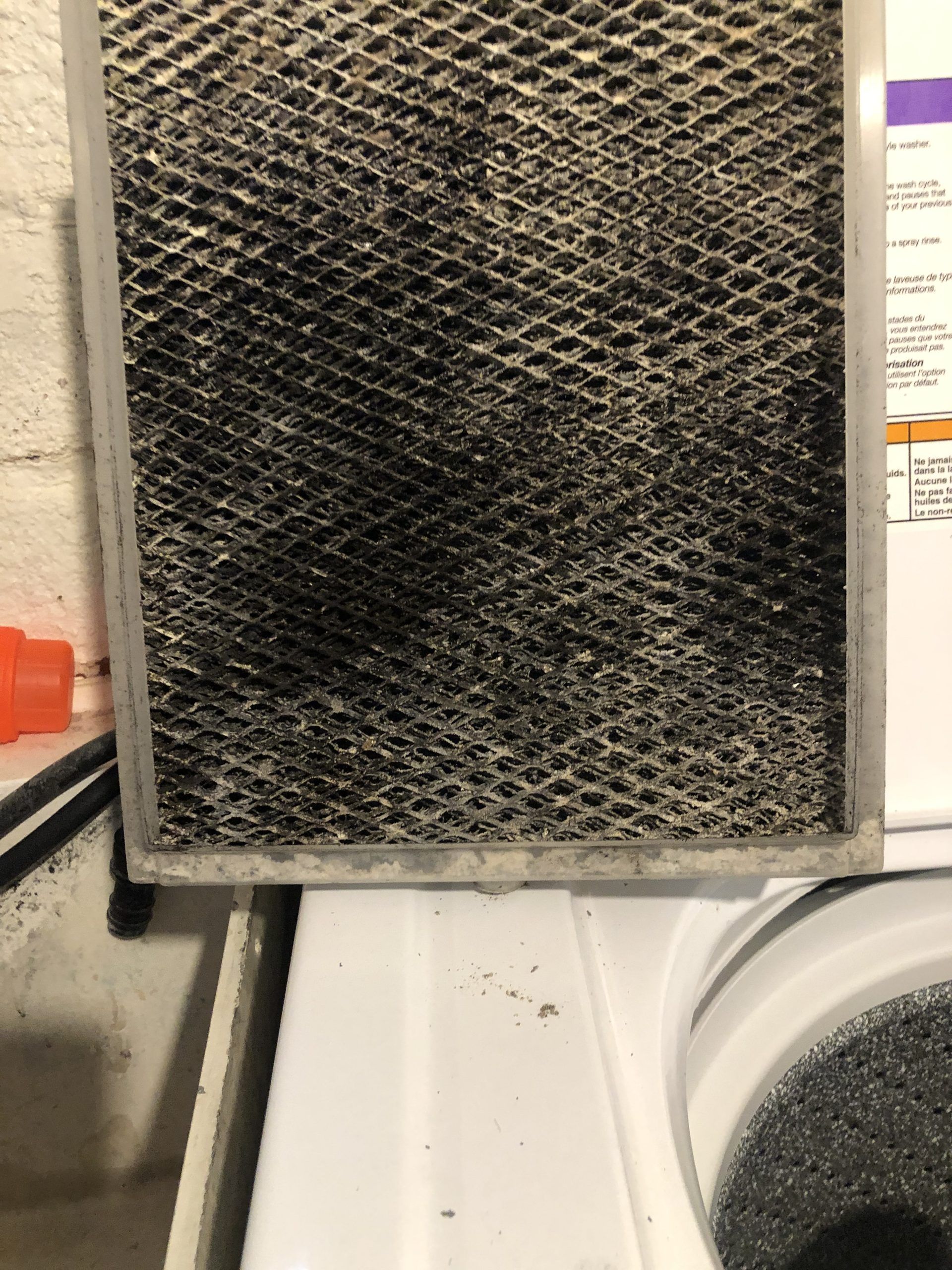 Dirty, clogged air filter removed from its housing, showing accumulated dust and debris.