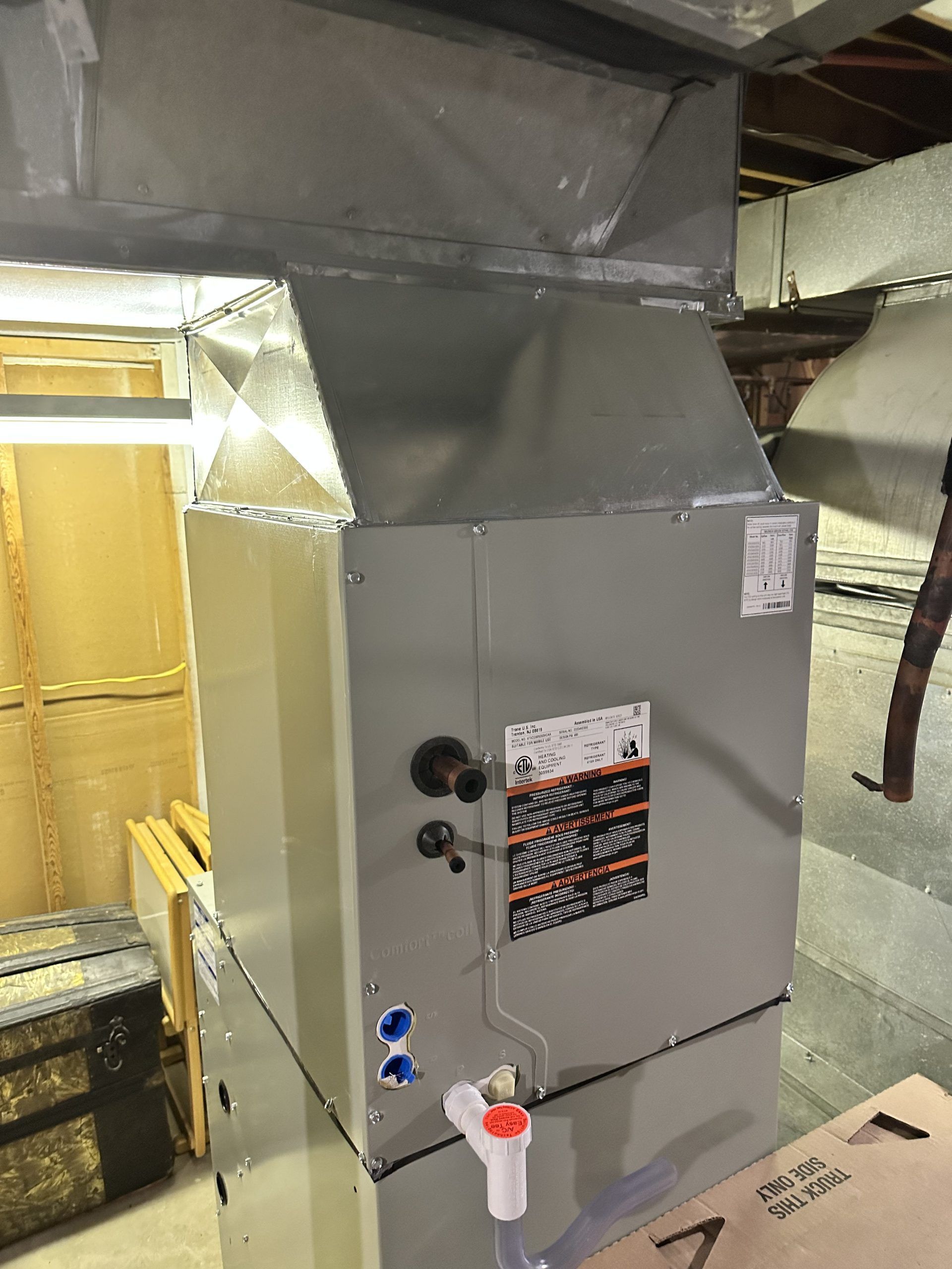 A new HVAC unit with ductwork in a basement setting.