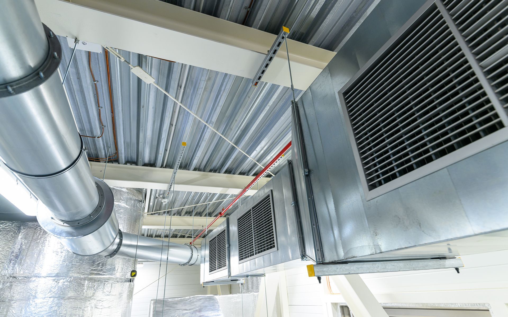 Air conditioning and ventilation system installed on a ceiling, metal ducts and grilles visible.