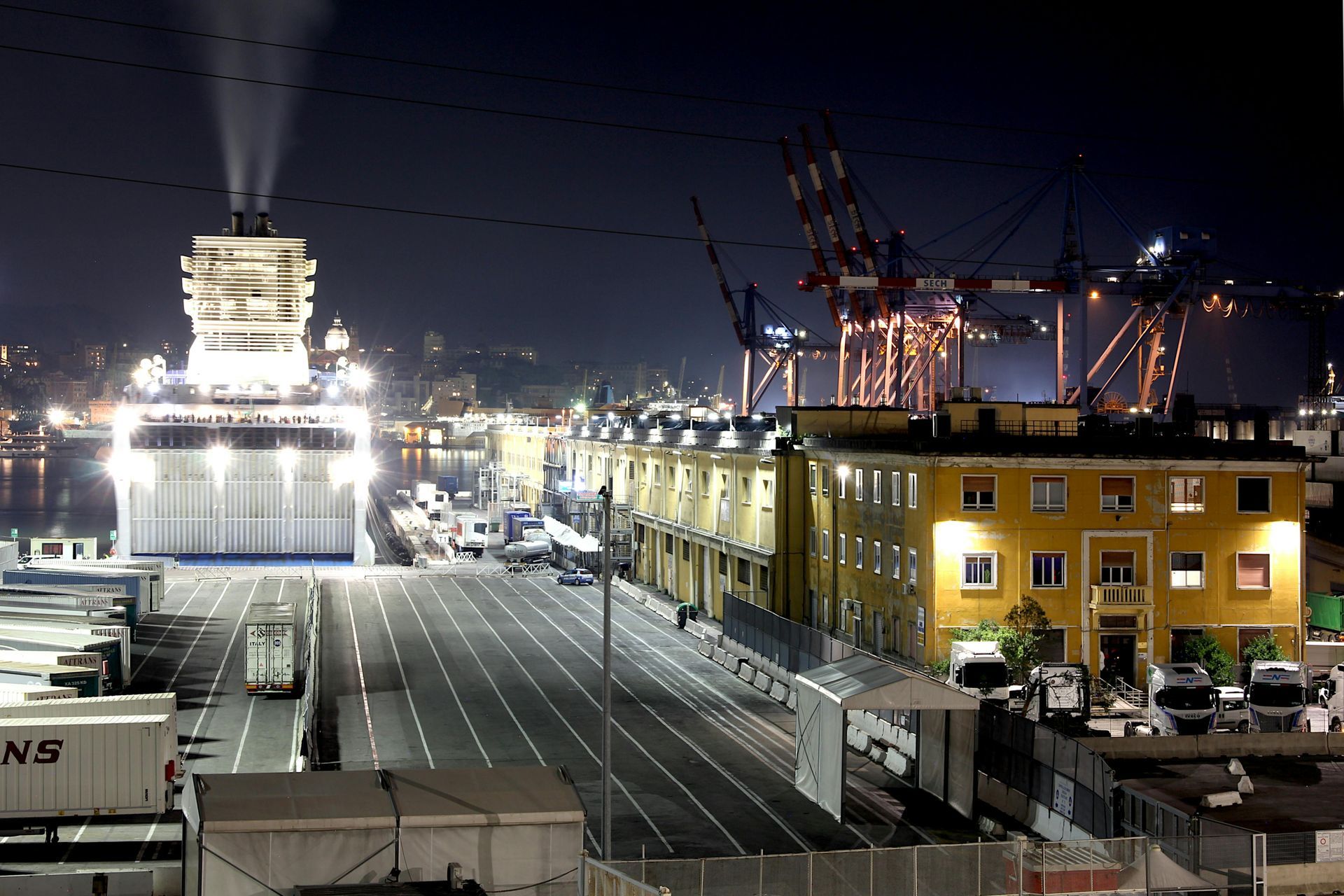 A large ship is docked in a harbor at night