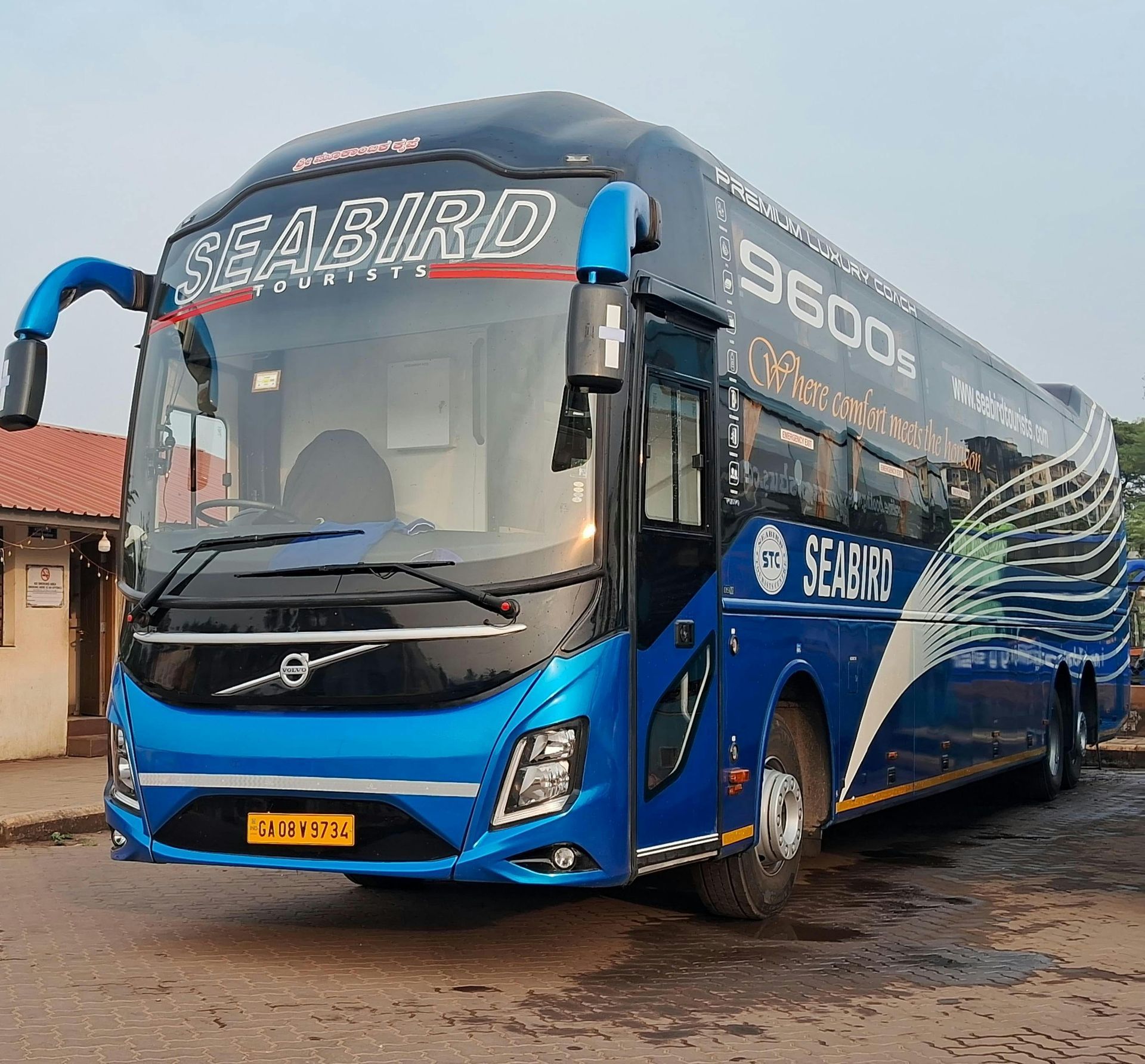 A blue seabird bus is parked in front of a building