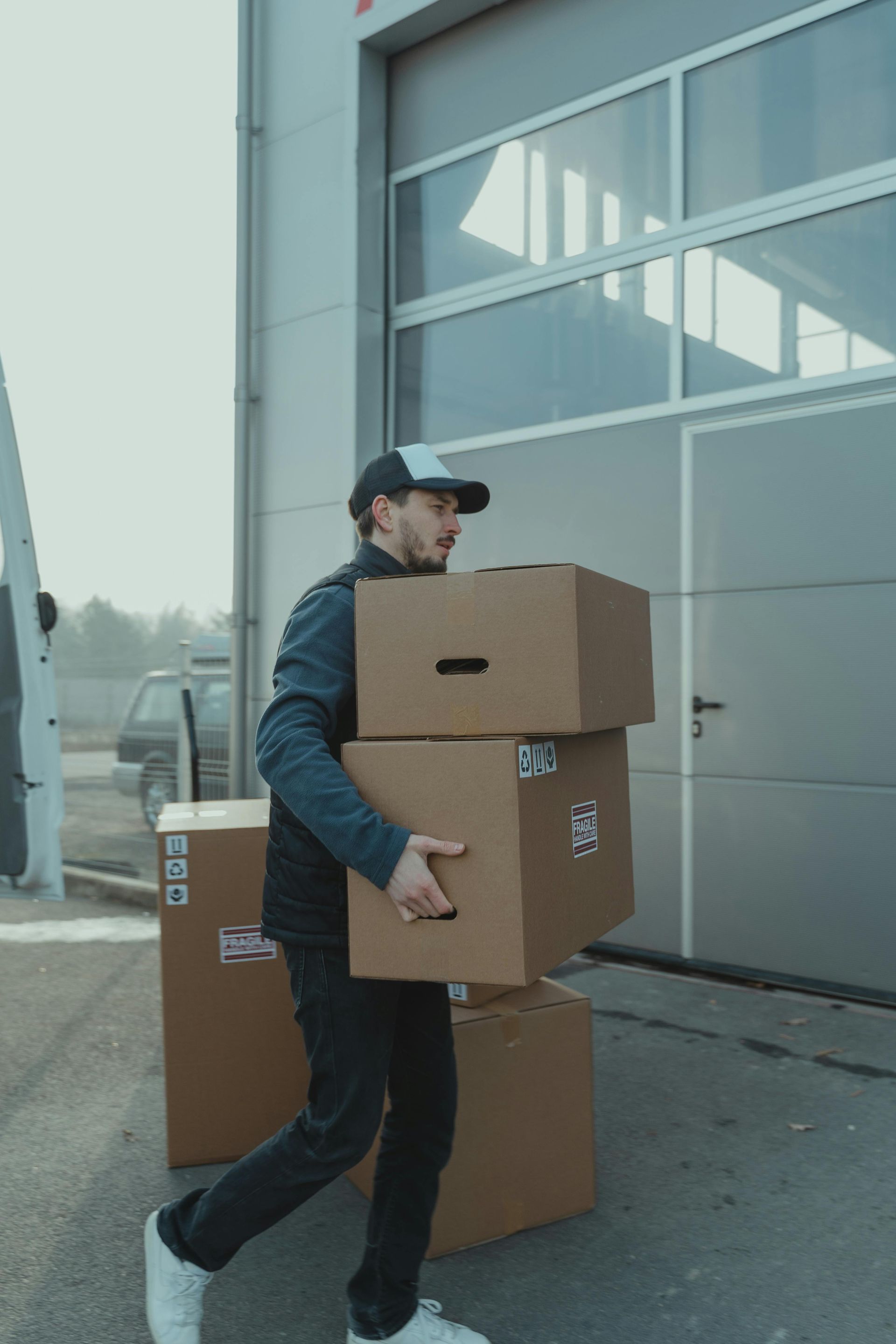 A man is carrying a stack of cardboard boxes.