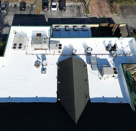 An aerial view of a large building with a white roof.