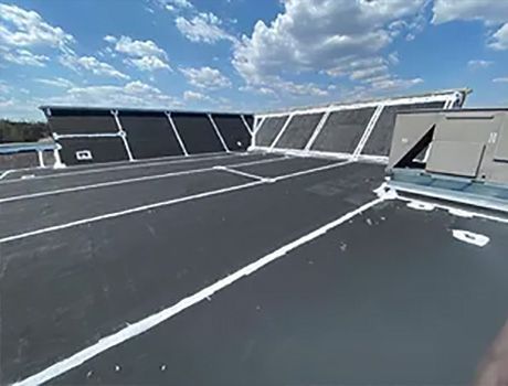 A parking lot on the roof of a building with a blue sky in the background.