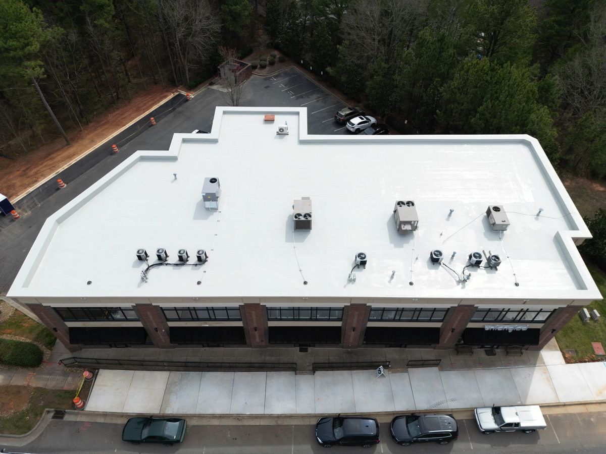 An aerial view of a building with a white roof